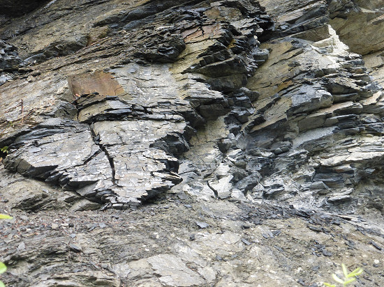 Brüchige Schieferwand am Weg